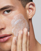 Primo piano di un uomo che applica la crema Raso sulla guancia